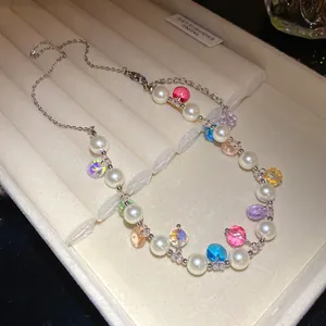 Close-up detail of an asymmetric pearl necklace with vibrant multi-colored beads.