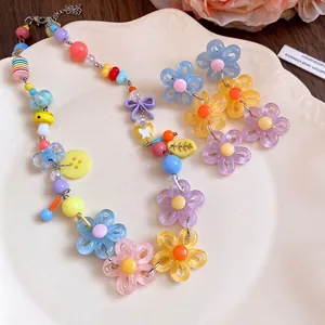 Colorful dopamine style daisy beaded necklace and flower earrings on a white plate