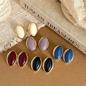 Detail of vintage oval stud earrings in multiple colors with elegant gold-tone edges.