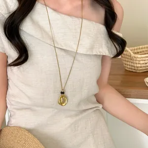 Elegant Korean style long necklace with a gold wrinkled round pendant and black bead