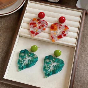 Detailed macro view of colorful marbled resin leaf earrings with silver needle posts