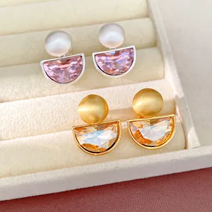 Dettaglio di orecchini a clip in cristallo a semicerchio rosa e oro ambrato in astuccio