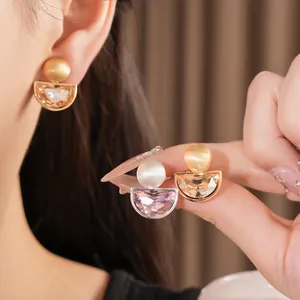 Dettaglio di orecchini a clip minimalisti a semicerchio con strass per donna senza buco.