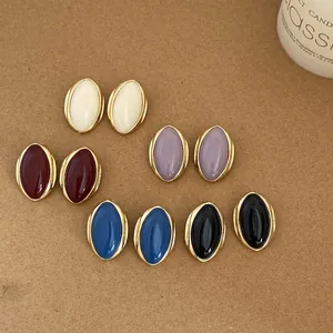 Collection of vintage oval stud earrings in various colors with elegant gold-tone borders.