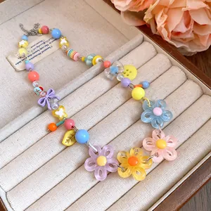 Colorful dopamine style beaded necklace featuring acrylic daisy and bow charms!
