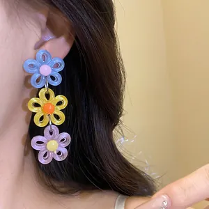 Detailed close-up showing colorful dopamine style acrylic triple daisy drop earrings on model ear