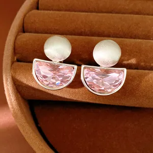 Dettaglio di eleganti orecchini a clip a semicerchio con cristalli rosa in scatola di velluto