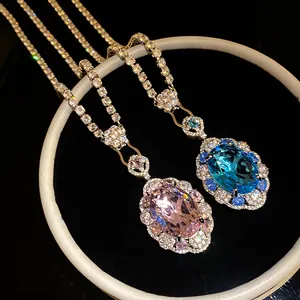 Close-up of luxury oval zircon pendants in pink and blue with sparkling halo settings