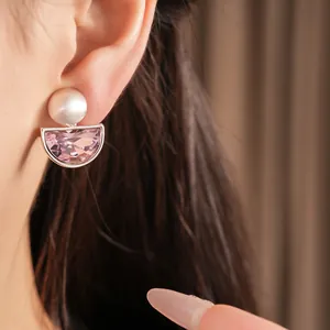 Primo piano di eleganti clip per orecchie a semicerchio con cristallo rosa e sfera argento