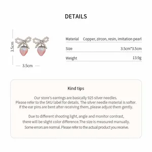 Detail view of bow strawberry pearl earrings with materials and size specifications
