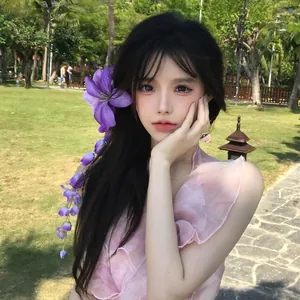 Vue détaillée d'une pince à cheveux fleur violette avec de longs glands sur un mannequin.