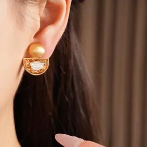 Dettaglio elegante clip orecchio semicerchio dorata con strass ambra