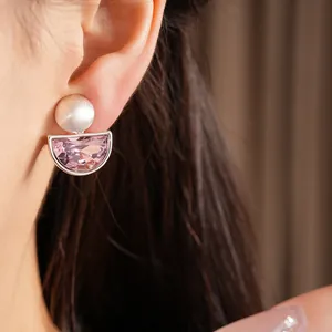Dettaglio di eleganti clip per orecchie in cristallo rosa semicircolare su una donna