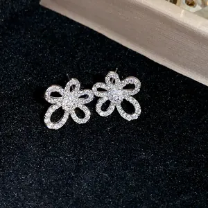 Detailed macro shot of elegant silver flower stud earrings adorned with sparkling zircons