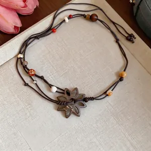 Handmade leather cord necklace with coconut shell flower pendant and wooden beads