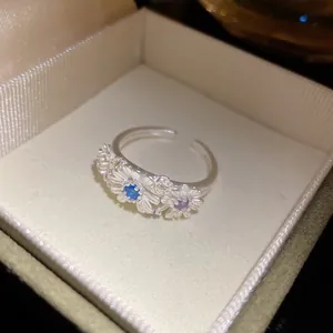 Detailed view of a sweet daisy flower ring with colorful gemstones in a gift box.