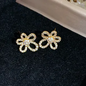Detailed close-up showing the sparkling zircon petals of these 18k gold plated flower stud earrings