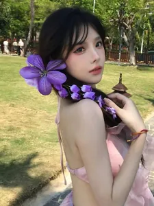 Vue détaillée d'une pince à cheveux fleur violette surdimensionnée avec pampille sur un mannequin