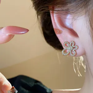 Detailed close-up view of elegant gold plated flower stud earring with shimmering zircon