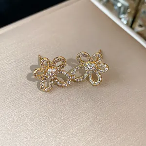 Detailed view of 18k gold plated flower stud earrings with sparkling cubic zirconia
