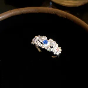 Detailed macro view of a silver daisy flower ring with colorful gemstone petals