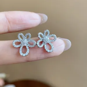 Close-up of elegant 18k gold plated silver needle zircon flower stud earrings