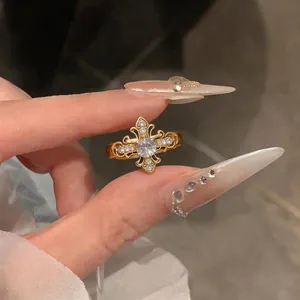 Macro view of a gold fleur-de-lis cross ring with sparkling zircon embellishments