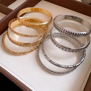 Elegant geometric gold and silver metal bangle set for women in jewelry display tray