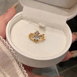 Elegant close-up shot of a zircon cross fleur-de-lis ear cuff presented in a white jewelry box.
