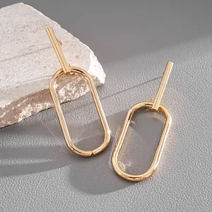 Detailed close-up of gold geometric oval link earrings featuring minimalist metallic design