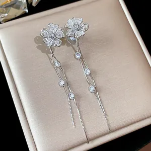 Close-up of elegant silver flower tassel earrings decorated with sparkling zircon stones