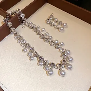 Elegant silver-toned necklace and earring set featuring rhinestones and white pearls