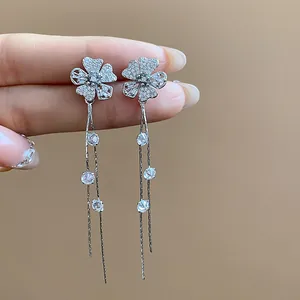 Close-up detail of silver needle flower tassel earrings with shimmering white cubic zirconia