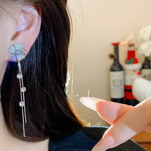 Exquisite zircon flower tassel stud earrings detailed view on female model's ear.