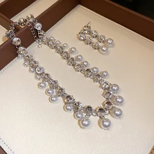 Detailed view of elegant sparkling rhinestone and white pearl necklace and earrings jewelry set