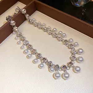 Detailed view of luxury rhinestone and faux pearl tassel choker necklace with silver finish