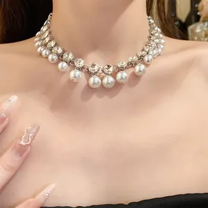 Elegant vintage rhinestone and pearl choker necklace featured on a model's neck detail