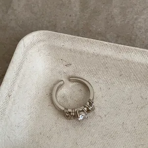 Primo piano di un anello regolabile in argento vintage con zircone e dettagli intrecciati
