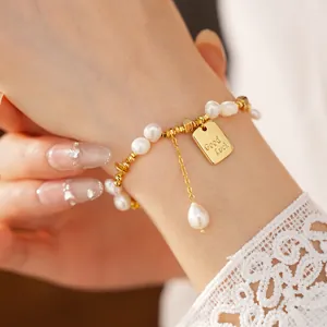 Dettaglio bracciale di perle placcato oro 18K con ciondolo Good Luck e goccia di perla