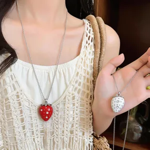 Dettaglio delle collane fragola con strass indossate sul collo di una modella