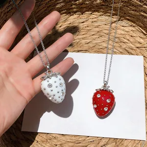 Dettaglio di graziose collane a fragola in resina con strass di cristallo lucenti