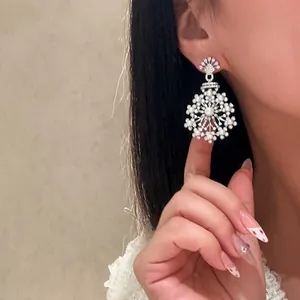 Detailed view of elegant silver flower pendant earrings with sparkling zircons and pearls