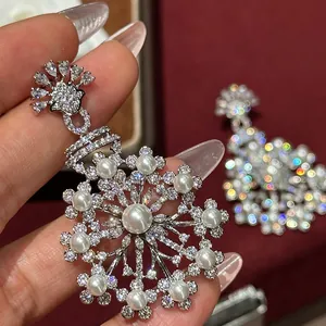 Close-up detail of silver floral drop earring set with sparkling zirconia and white pearls
