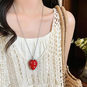 Dettaglio di una collana con ciondolo a fragola in resina rossa con strass scintillanti