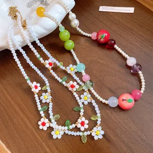 Close-up of colorful fruit and floral beaded necklaces with pearls and resin charms