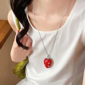 Dettaglio di una collana con ciondolo a fragola in resina rossa con strass scintillanti