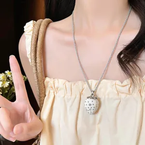 Dettaglio ravvicinato di una collana con ciondolo a fragola in resina bianca su modella
