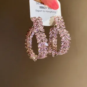 Elegantes pendientes de aro de circonita rosa en forma de trigo con piedras muy brillantes.