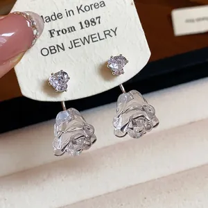 Detailansicht der Ohrringe mit Herz-Zirkonia und Rosenanhänger aus Kunstharz im Korea-Stil.
