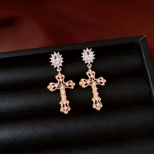 Luxe 18k vergulde zirkoon kruis oorbellen gepresenteerd in een zwarte sieradendoos.